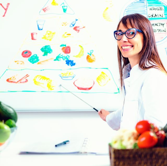 Portrait Of Female Nutritionist Showing Chart In Hospital
