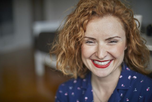 portrait of happy redheaded woman at home