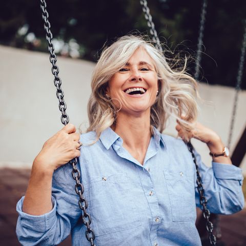 portrait of mature woman with gray hair sitting on swing