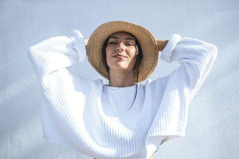 Portrait of smiling young woman wearing straw hat