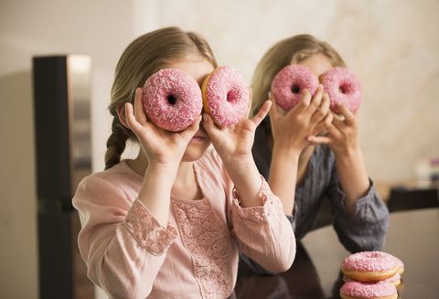 portrait of two sisters with donut holes over their eyes