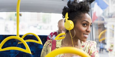 Portrait of woman relaxing on a bus wearing headphones