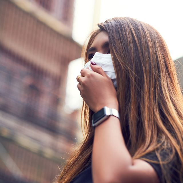 portrait of woman with medical mask standing on road in city  epidemic , pollution and allergy