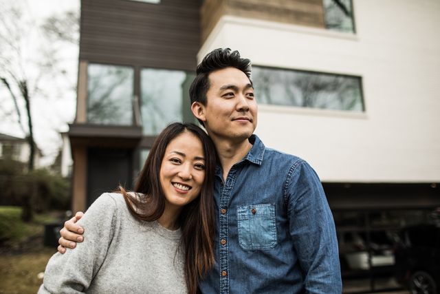 portrait of young couple in front of new home