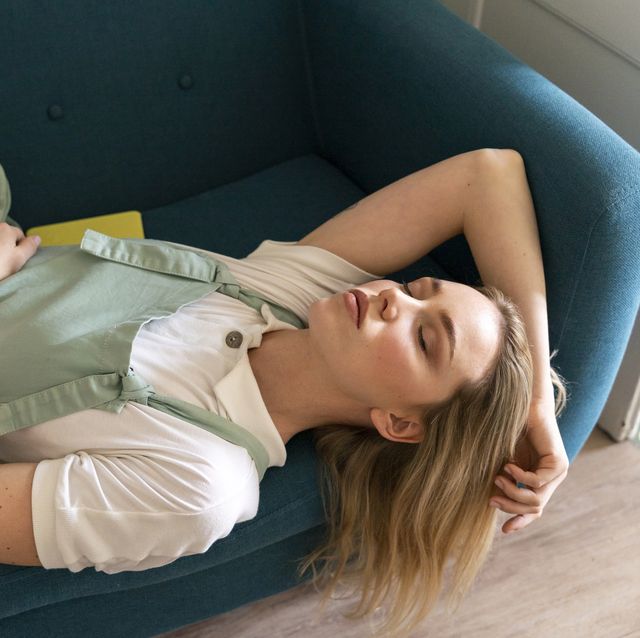 portrait of young woman lying on couch with closed eyes