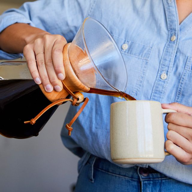 woman pouring coffee into mug from pour over coffee maker
