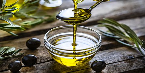 pouring extra virgin olive oil in a glass bowl