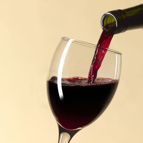 pouring glass of red wine with copy space