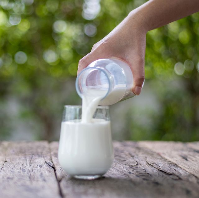 pouring milk on drinking glass, healthy eating concept