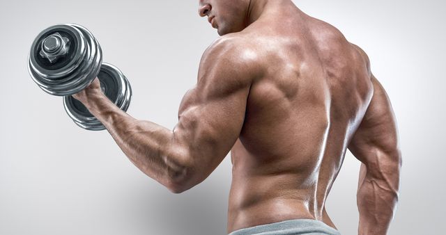 power athletic man in training pumping up muscles with dumbbells