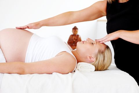 Pregnant woman receiving reiki healing