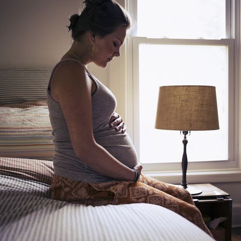 mujer embarazada sentada en la cama