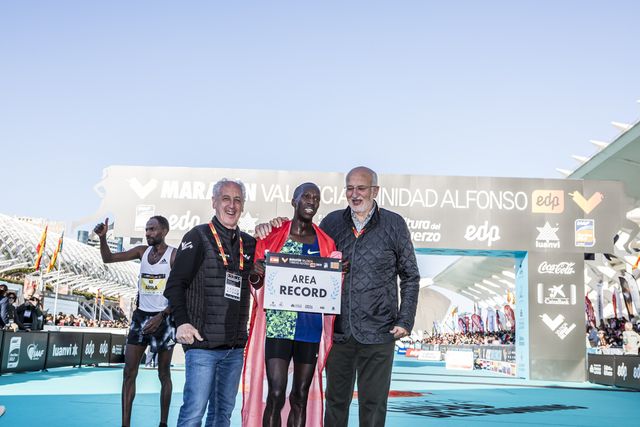 paco borao y juan roig escoltan al atleta etíope ayalew tras batir el récord de área y llevarse un premio económico en el maratón de valencia 2019