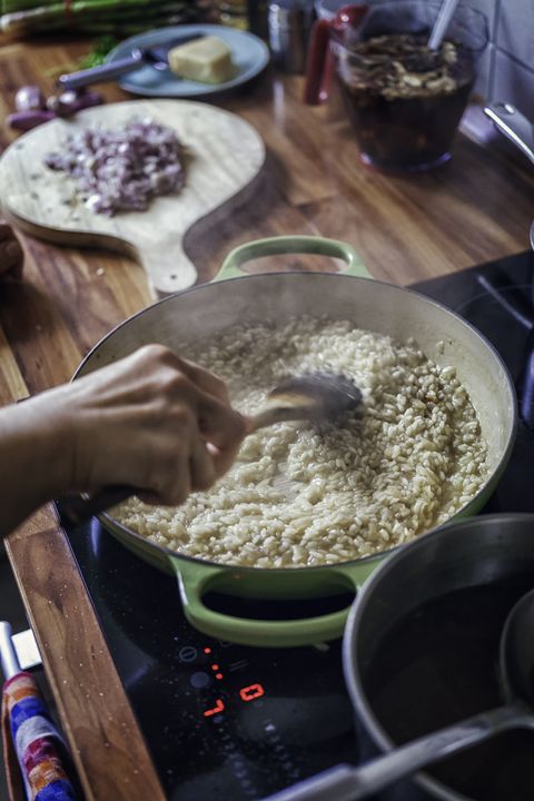 preparing risotto bianco served with parmesan