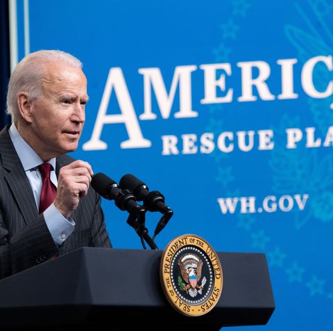 joe biden standing in front of a sign that says american rescue plan