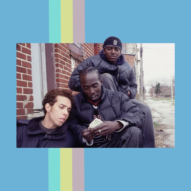 three men, including omar little, looking at money, sitting on a step in the street
