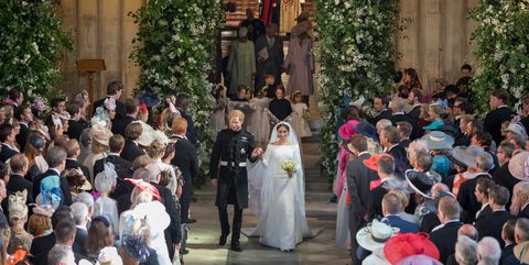 Meghan Markle holding Prince Harry's hand walking down the aisle of St. George's chapel.