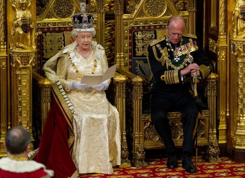 the queen reads a speech while on her throne as prince philip listens next to her