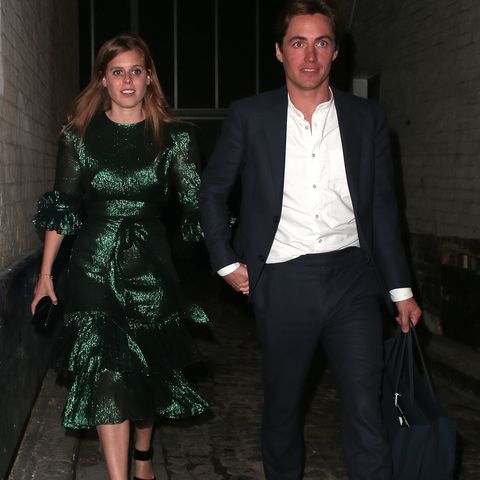 Princess Beatrice walking through the street in a glamorous green dress holding hands with her smartly dressed fiance, Edo Mapelli Mozzi.