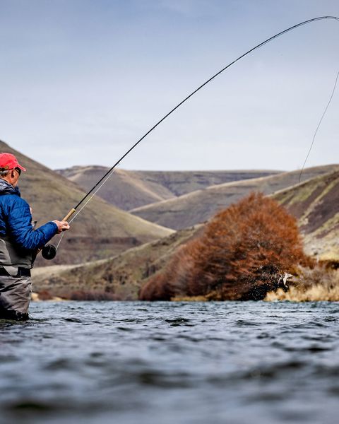 a man fishing in a river with the microspey air 2 rod