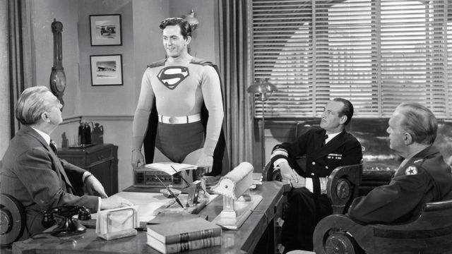 kirk alyn caracterizado como superman en una reunión de trabajo