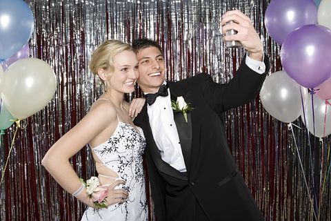 Teenage boy and girl taking a photo at the prom