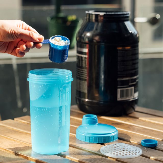 person mixing protein into shaker bottle