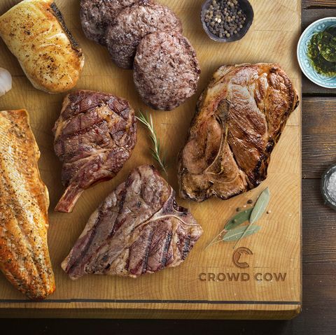 crowd cow cutting board with steak, chops, fish, and burgers