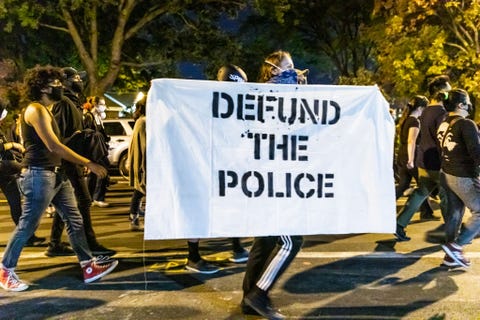 protestor carries "defund the police" sign in chicago in september 2020