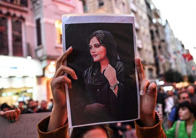 protester-holds-a-portrait-of-mahsa-amini-during-a-news-photo-1663844952.jpg