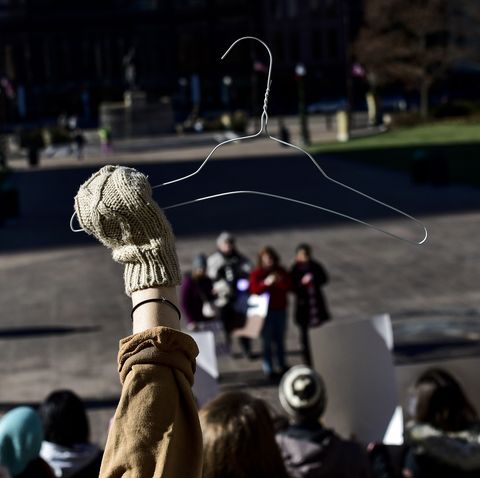 A protester seen holding a coat hanger which is an emblem of...