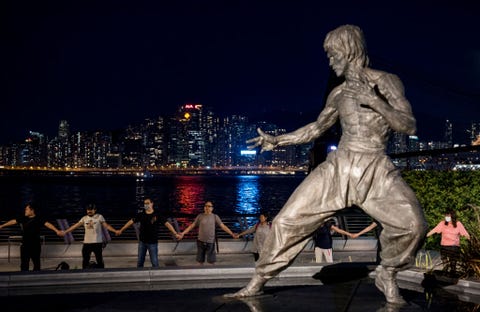 Protesters hold hands to form a human chain next to a Bruce...