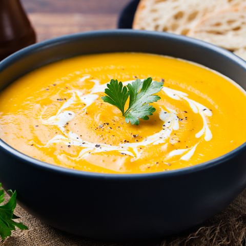 Pumpkin and carrot soup with cream and parsley