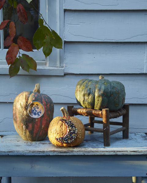 three pumpkins decorated with celestial designs