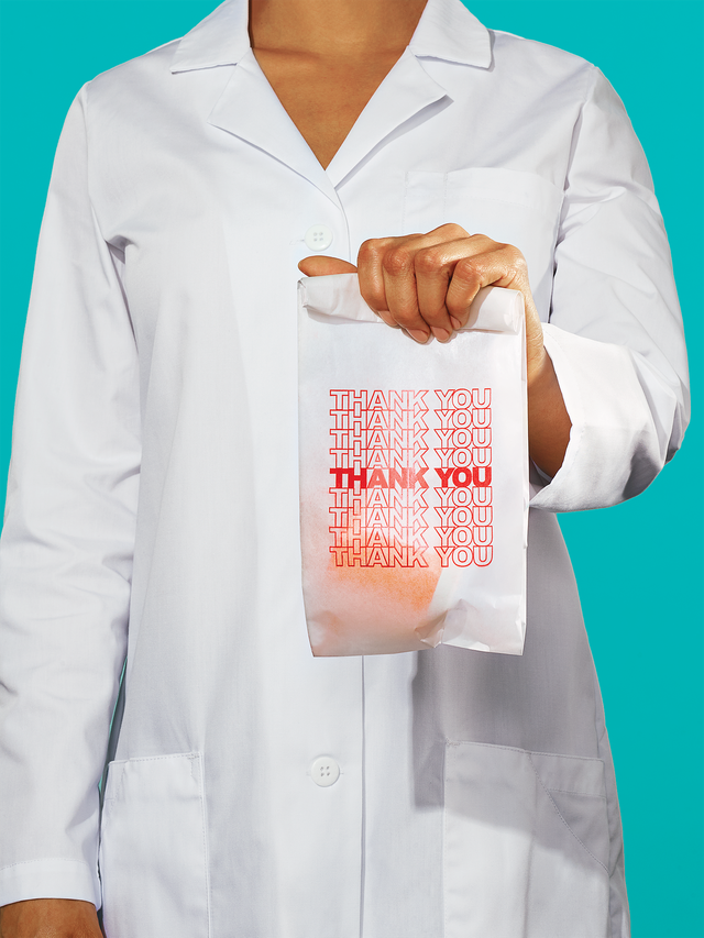 pharmacist holding a prescription bag reading "thank you"