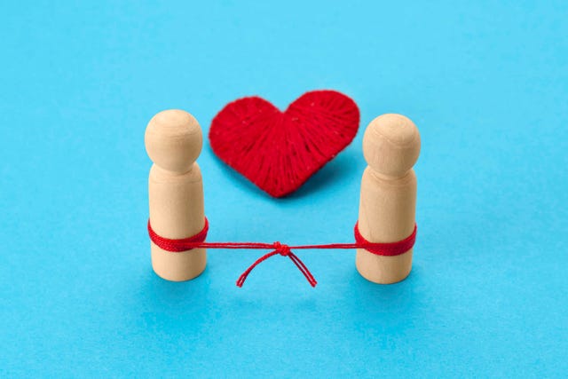 become reconciled couple figures of people with a knitted thread, a heart as a symbol of love
