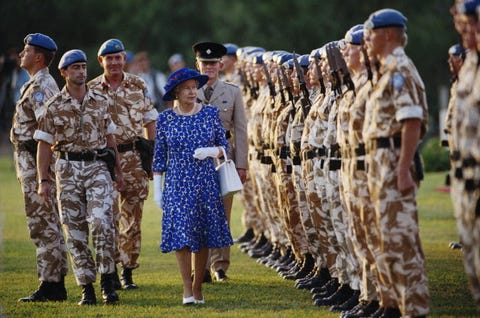 queen elizabeth ii, wearing a blue and white dress with a blue hat, inspects un peacekeeping troop