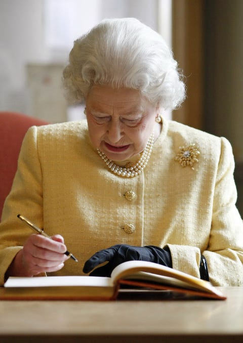 queen elizabeth ii signs the visitor's book at the royal academy of music