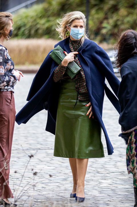 koningin maxima loopt in groene leren rok met blauwe jas