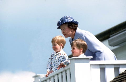 queen sits atop a balcony with a young prince william and harry