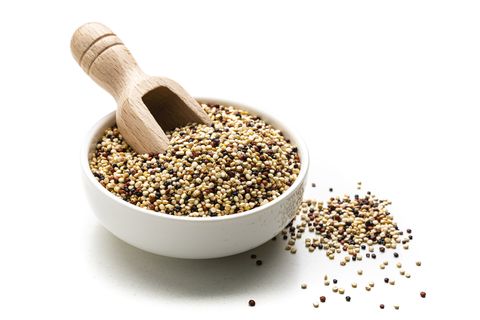 close up view of a white bowl filled with a mixture of red, black and white quinoa seeds