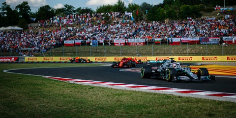 Racing drivers steer their cars during the formation lap...