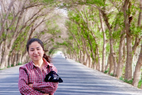 dawut standing in village tree tunnel in the southern part of the uyghur region, 2005