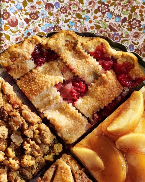a quarter of an apple and raspberry pie in a pie pan with three other quarters of different flavors