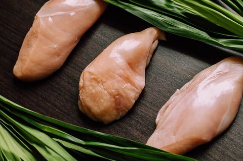 raw chicken breast fillets and pandan leaves on a wooden table