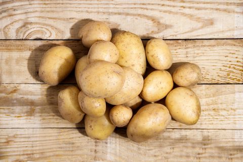 raw potatoes on wooden background