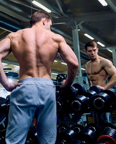 Rear view of a sporty man with muscles in the gym