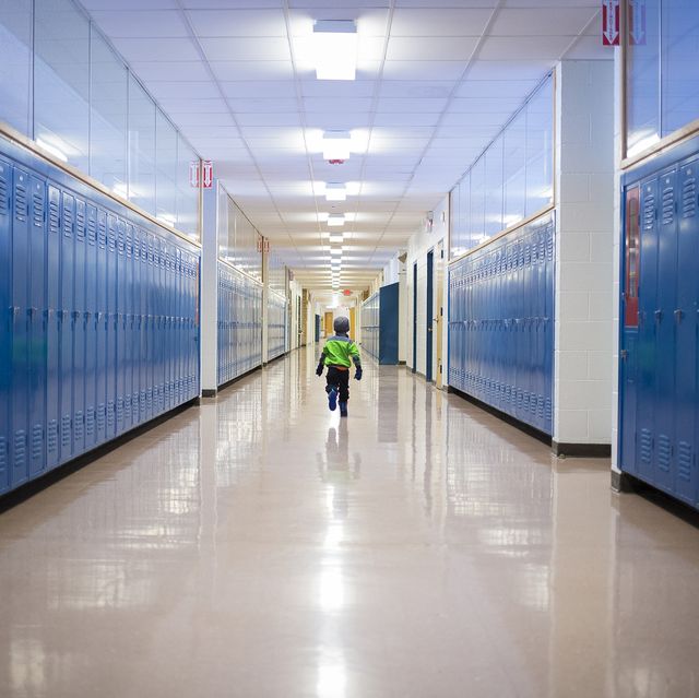 Rear view of boy running in school corridor