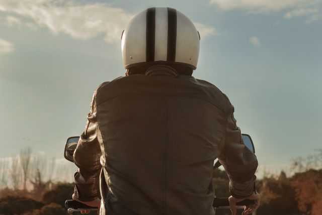 rear view of man riding motorcycle against sky