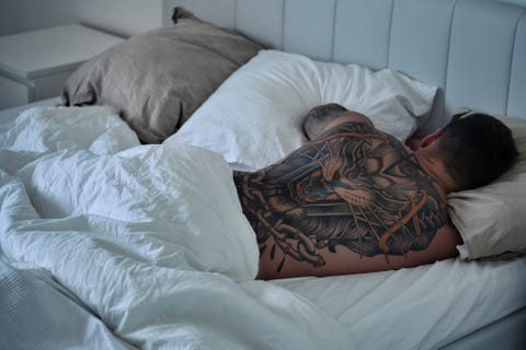 Rear View Of Man With Tattoo Sleeping On Bed rear view of man with tattoo sleeping on bed